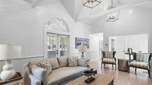 A spacious living room with a large sofa, two armchairs, a coffee table, and a chandelier. - Renovated to Studs in Seaside w/3K Kings! 5 Min Walk to Beach + 2 Bikes! (Santa Rosa Beach)
