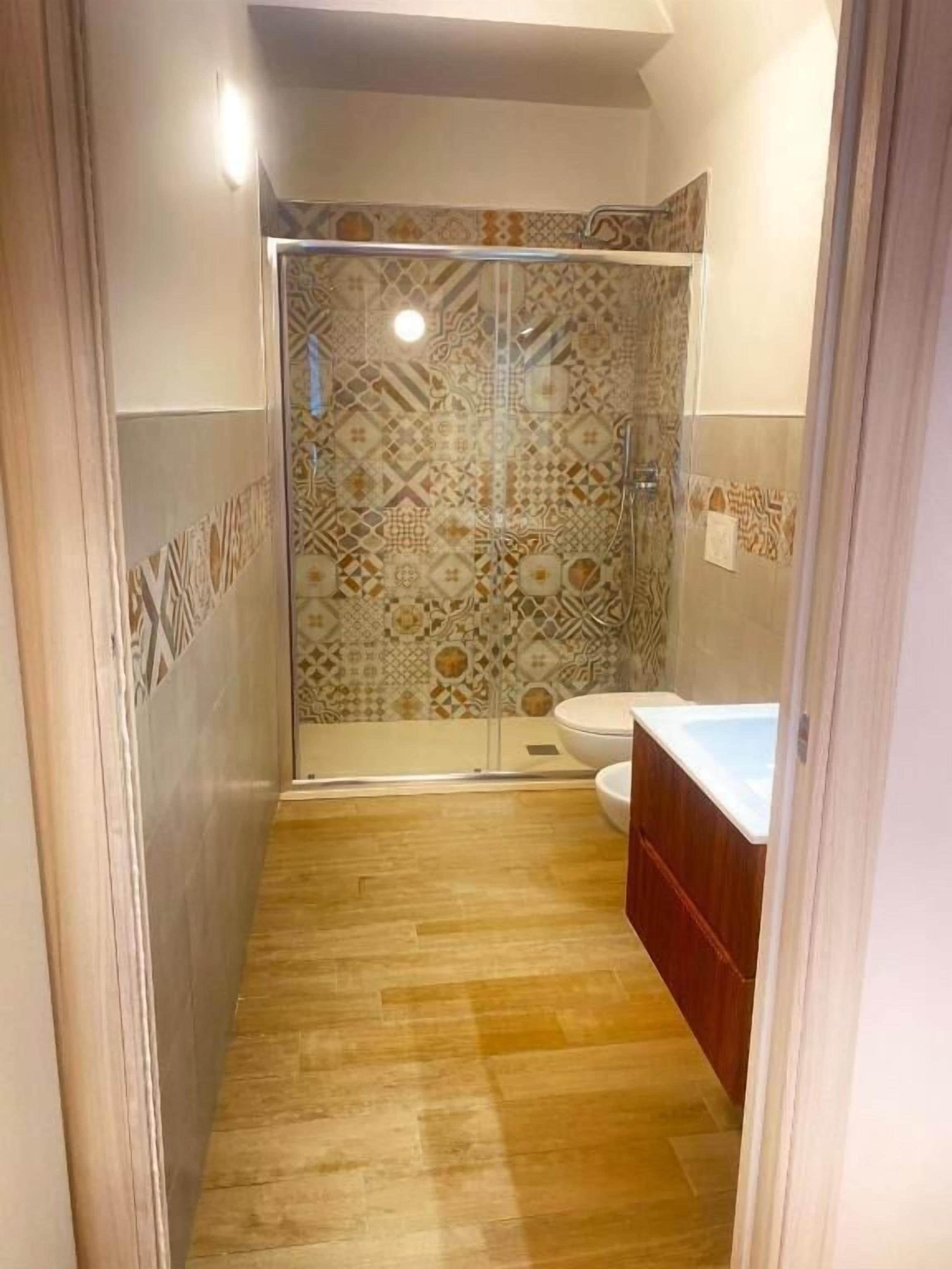 A bathroom with a shower, toilet, and sink.