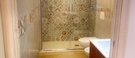 A bathroom with a shower, toilet, and sink.