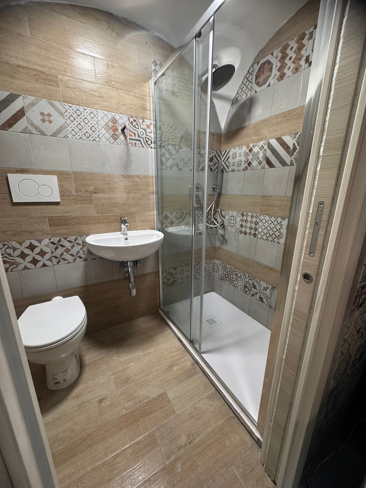 A bathroom with a shower, toilet, and sink.