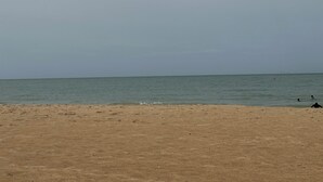 A beach with a sandy shore and calm sea.