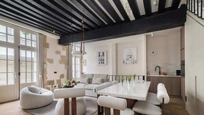 A modern interior with a dining area, sofa set, and kitchen. - An Exceptional 3-BR/3Ba with Services - Le Marais (Paris)