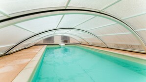 An indoor swimming pool with a curved roof structure. - Guest Room 'Laurier Rose' with Shared Pool, Wi-Fi, and Air Conditioning (Piolenc)