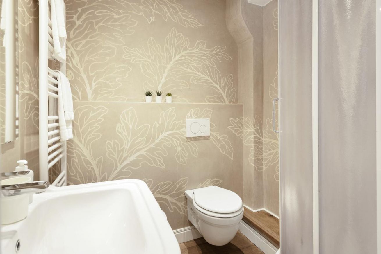 A bathroom with a toilet, sink, and shower.