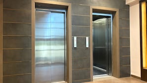 A modern elevator with a metallic finish and a control panel on the wall. - Hotel Maheshwaram Vijay Nagar Indore (Indore)