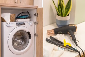 A washing machine and a hair straightener on a countertop. - Stylish Love Nest W/ Balcony in Heart of Koukaki! (Athina)