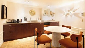 Een moderne keuken met een centraal eiland, een ronde eettafel met stoelen en decoratieve wanddecoraties.