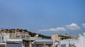A rooftop with industrial equipment, including large cylindrical tanks and satellite dishes, under a clear blue sky. - Romantic Island in the Sky, Acropolis & City Views (Athina)
