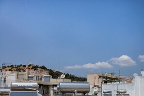 A rooftop with industrial equipment, including large cylindrical tanks and satellite dishes, under a clear blue sky. - Romantic Island in the Sky, Acropolis & City Views (Athina)