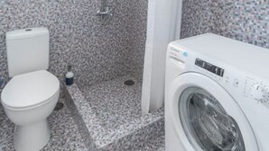 A bathroom with a shower, toilet, and washing machine. - Romantic Island in the Sky, Acropolis & City Views (Athina)