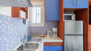 A compact kitchen with a stainless steel sink, a microwave, and a refrigerator. - Romantic Island in the Sky, Acropolis & City Views (Athina)