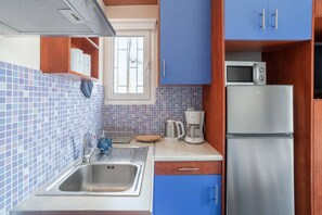 A compact kitchen with a stainless steel sink, a microwave, and a refrigerator. - Romantic Island in the Sky, Acropolis & City Views (Athina)