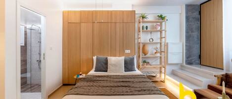 Ein modernes Schlafzimmer mit einem großen Bett, einem Kleiderschrank, einem Nachttisch, einer Lampe und einem Regal mit Pflanzen.