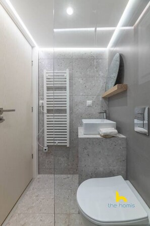 A modern bathroom with a toilet, sink, and shower area. - Kypseli's Dreamy Studio Your Cosy Greek Oasis! (Athina)
