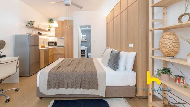 A modern bedroom with a bed, a desk, a chair, a wardrobe, and a shelf with plants. - Kypseli's Dreamy Studio Your Cosy Greek Oasis! (Athina)