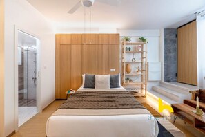 A modern bedroom with a large bed, a wardrobe, a bedside table, a lamp, and a shelf with plants. - Kypseli's Dreamy Studio Your Cosy Greek Oasis! (Athina)