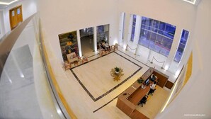 A spacious lobby with a reception desk, seating area, and large windows. - DAR AMMAR (El Djem)