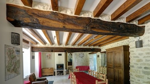 Ein rustikaler Essbereich mit Holztisch und -stühlen, einem Kamin und Steinwänden.