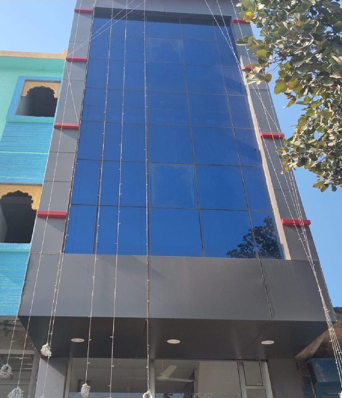 Ein modernes Gebäude mit einer großen Glasfassade und blauem Himmel im Hintergrund.
