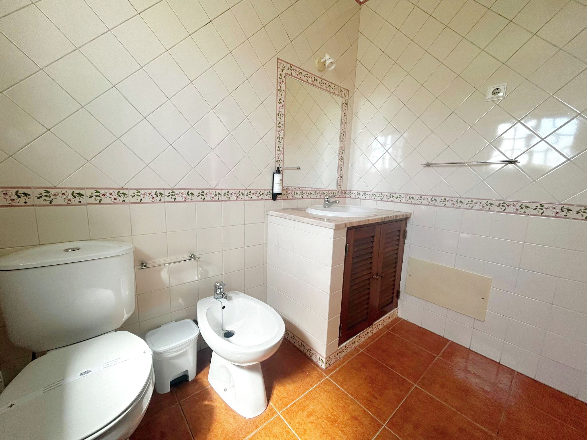 Un baño con inodoro, bidé y lavamanos, todo en color blanco.