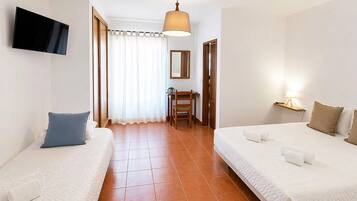 Une chambre d’hôtel avec deux lits, une télévision, un bureau et une chaise.