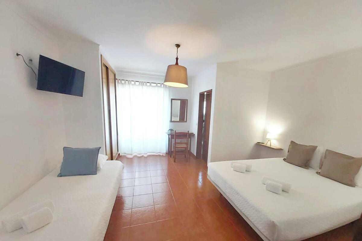 Una habitación de hotel con una cama, un sofá, un televisor, un escritorio y una silla.