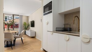 Cozinha moderna com micro-ondas, pia e bancada pequena.