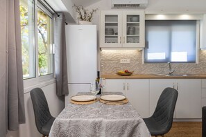 Een moderne keuken met witte kasten, een inbouwoven en een raam met gordijnen.