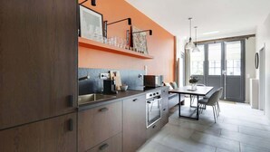 Eine moderne Küche mit einem dunklen Holzschrank, einer Arbeitsplatte mit einer Mikrowelle und einem Essbereich mit Tisch und Stühlen.