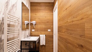 Une salle de bain moderne avec un mur en bois, un lavabo blanc et un porte-serviettes.