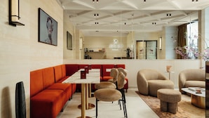 A modern interior with a sofa, chairs, a table, and a kitchen area. - Jills Hotel (Paris)