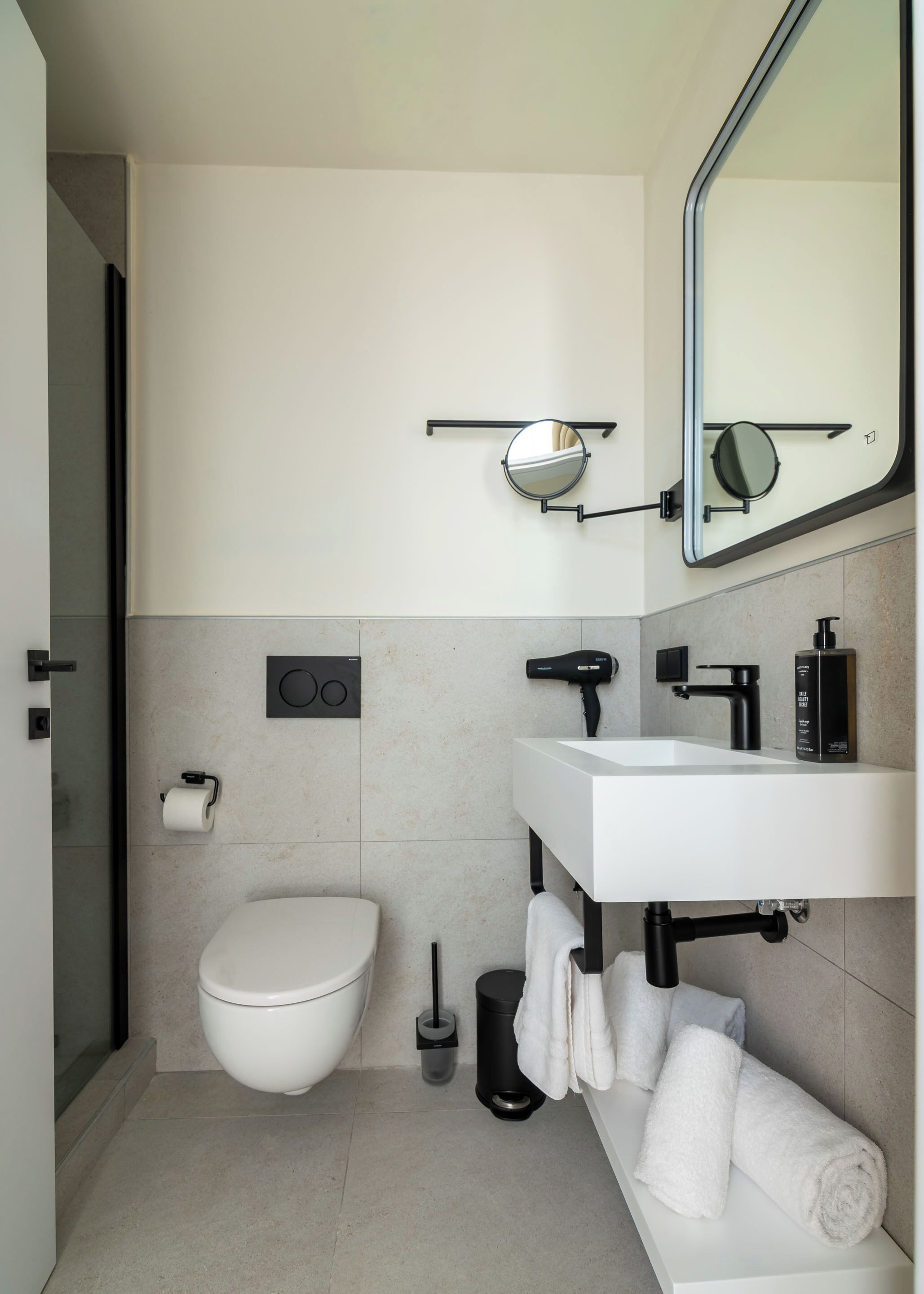 Un baño moderno con inodoro, lavabo y espejo.