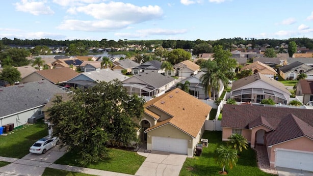 A residential neighborhood with single-family homes, well-maintained lawns, and a clear sky. - Sunshine Serenity Villa (Kissimmee)
