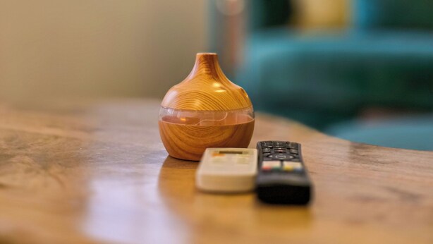 A wooden vase on a table with two remotes beside it. - Karaköy Port House  (Istanbul)