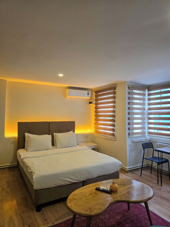 A hotel room with a bed, bedside table, and a small table with a remote control. - Karaköy Port House  (Istanbul)
