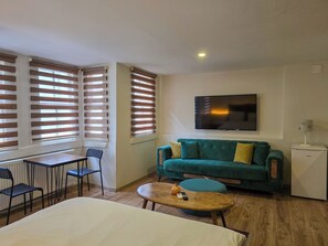 Standard-Dreibettzimmer | Wohnbereich | 22-Zoll-Flachbildfernseher mit Kabelempfang