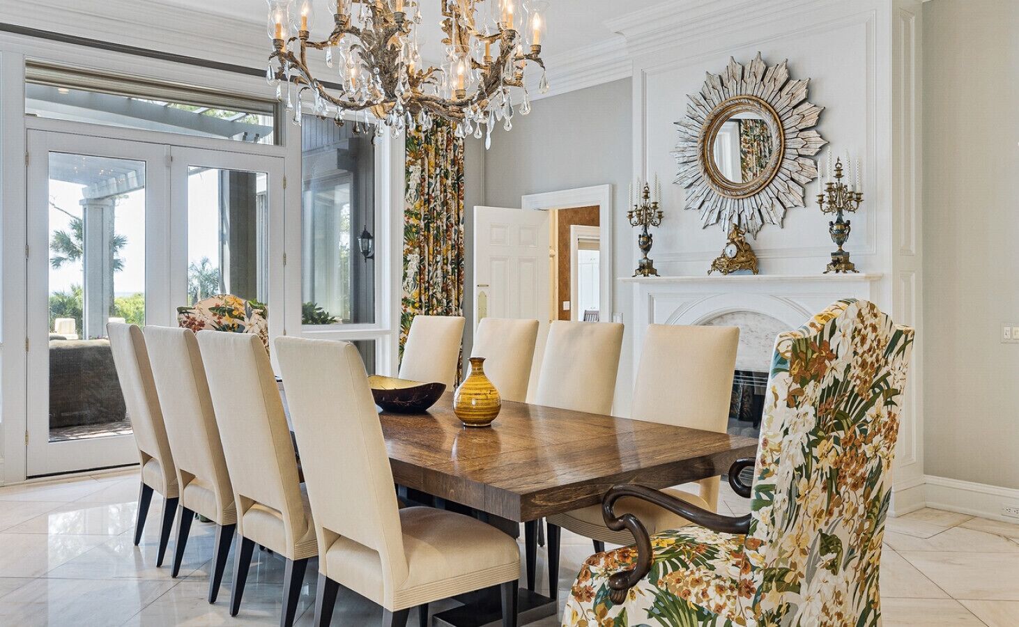 A dining room with a large wooden table, six chairs, and a chandelier.