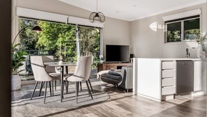 Una cocina moderna con comedor, ventanas amplias y un televisor de pantalla plana.