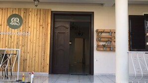 A building entrance with a wooden facade, a metal gate, and a sign with a logo and text. - Tirana • 2 Single Beds • Free Wi-Fi • Pet-Friendly • Shared Kitchen & Bathroom (Tiarana)