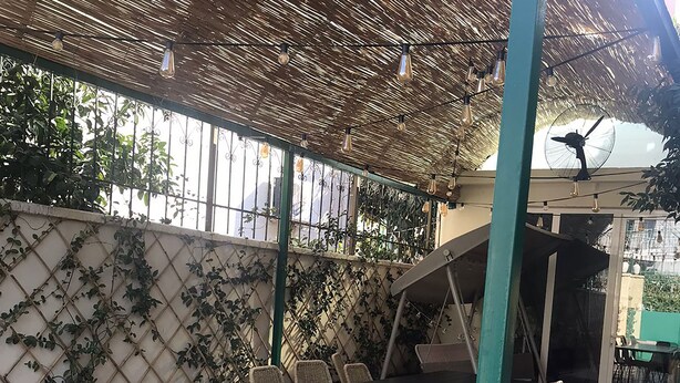An outdoor patio with a table and chairs, a fan, and a decorative ceiling. - Tirana • 2 Single Beds • Free Wi-Fi • Pet-Friendly • Shared Kitchen & Bathroom (Tiarana)
