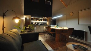 A modern interior with a dining area, kitchen, and a cozy seating space.