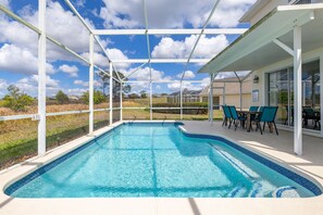 Piscina com um terraço coberto, área de estar externa e vista para a paisagem ao redor.