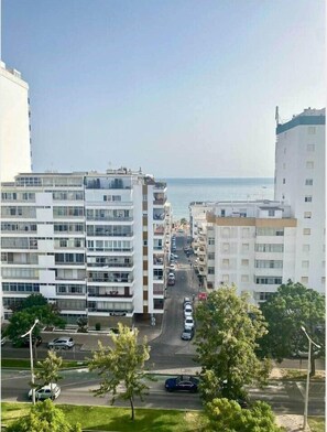 A multi-story residential building with a street in front. - Minimalist Nomad Seaside Apartment (Quarteira)