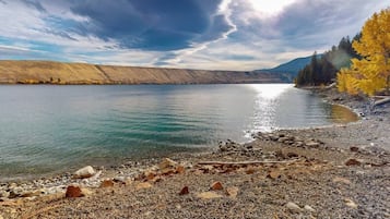 Un lac aux rives rocheuses, avec des arbres en arrière-plan.