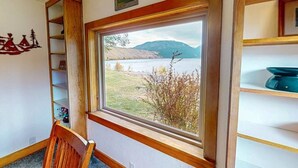 A room with a large window, wooden shelves, and a chair. - The View: stunning Wallowa Lake views! (Joseph)