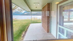 A covered porch with a view of a lake and mountains. - The View: stunning Wallowa Lake views! (Joseph)