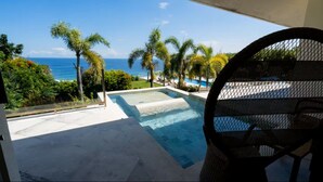 A pool with a view of the ocean and palm trees. - Villa Anugrah (Badung)