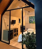 Um interior moderno com uma cama, uma escrivaninha e uma televisão.