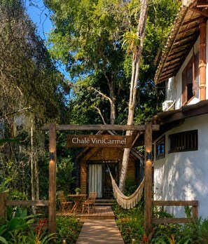 A wooden pergola with a sign reading 'Chalet ViniCarmel' in front of a white building with a wooden roof. - Pousada ViniCarmel (Porto Seguro)