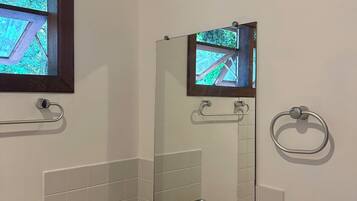 Bany amb un lavabo de superfície de granit, un mirall, una finestra i un anell per a tovallons.